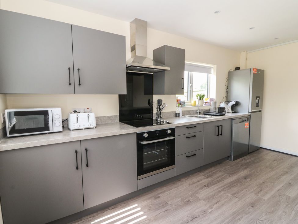 A kitchen with appliances and cabinetry at Glandwr House in Llandrindod Wells