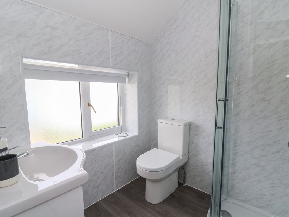 A bathroom with a sink, toilet, and shower at Glandwr House Llandrindod Wells