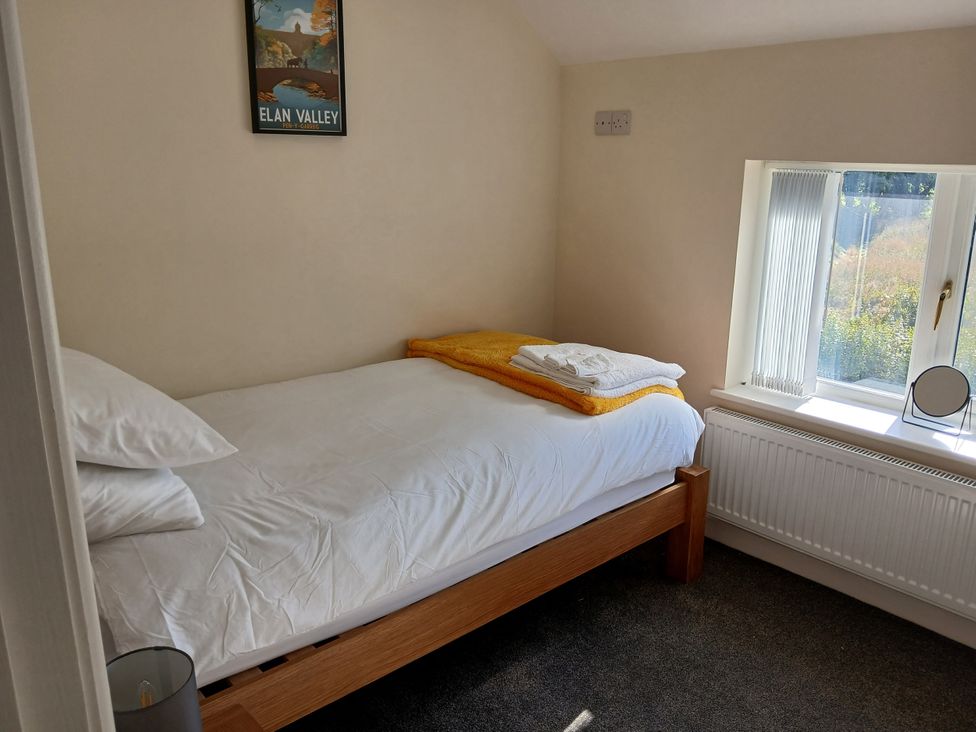 A bedroom with a single bed and towels at Glandwr House Crossgates near Llandrindod Wells