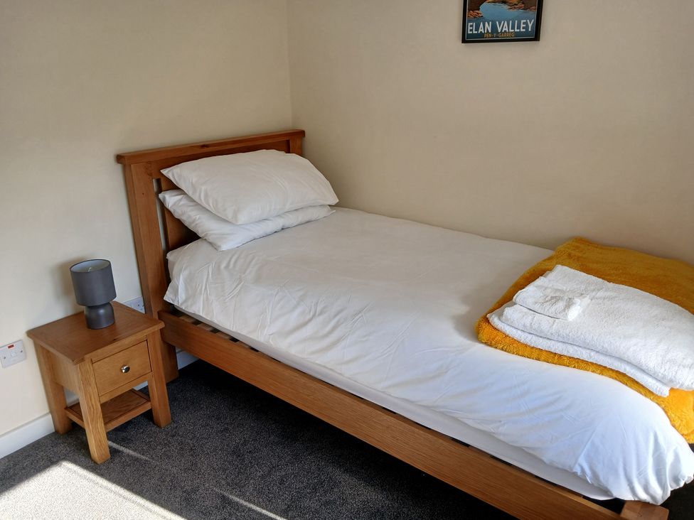 A bedroom with a bed and bedside table at Glandwr House Crossgates near Llandrindod Wells