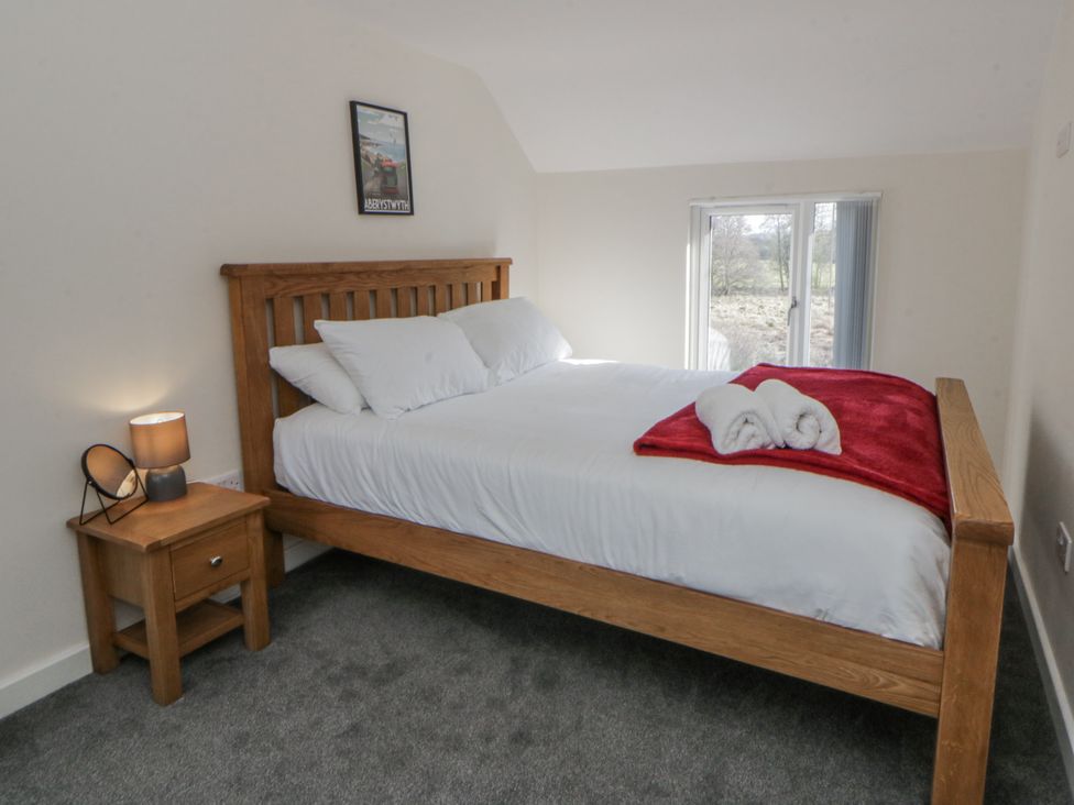 A bedroom with a bed and bedside table at Glandwr House in Crossgates near Llandrindod Wells