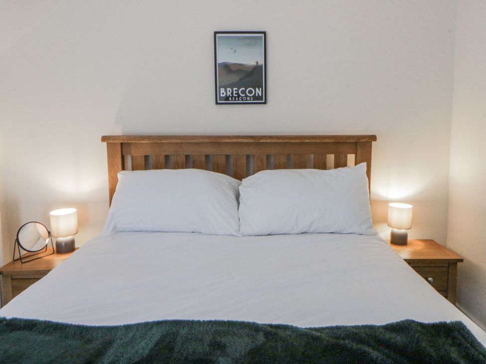 A bedroom with a bed, bedside tables and lamps at Glandwr House in Crossgates near Llandrindod Wells
