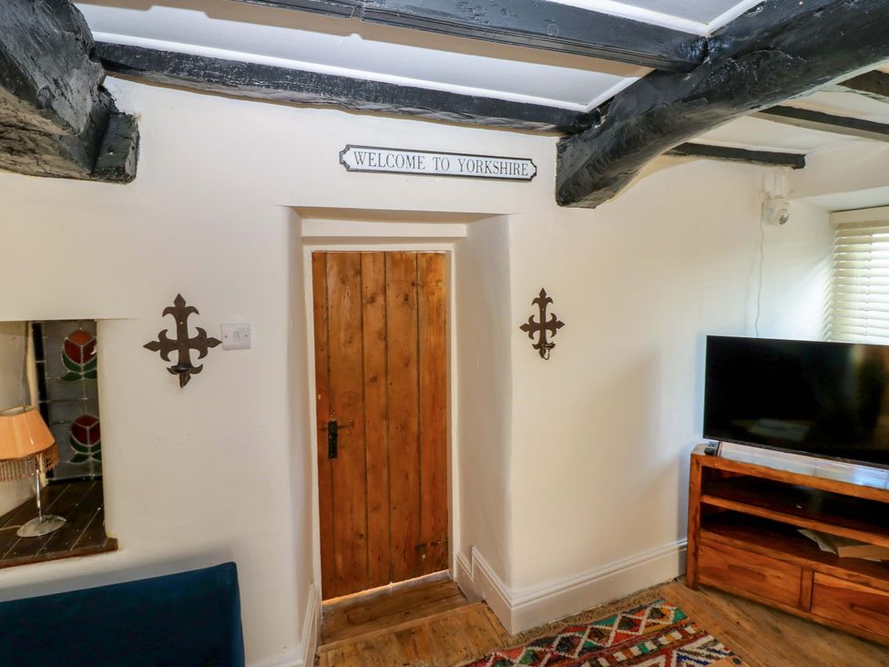 A living room with a door and a television at Eastend Cottage in 