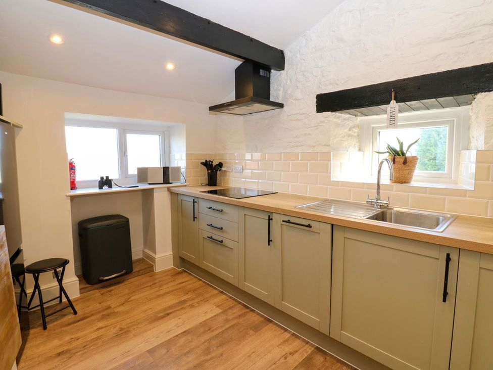 A kitchen with cabinets and a sink at Eastend Cottage