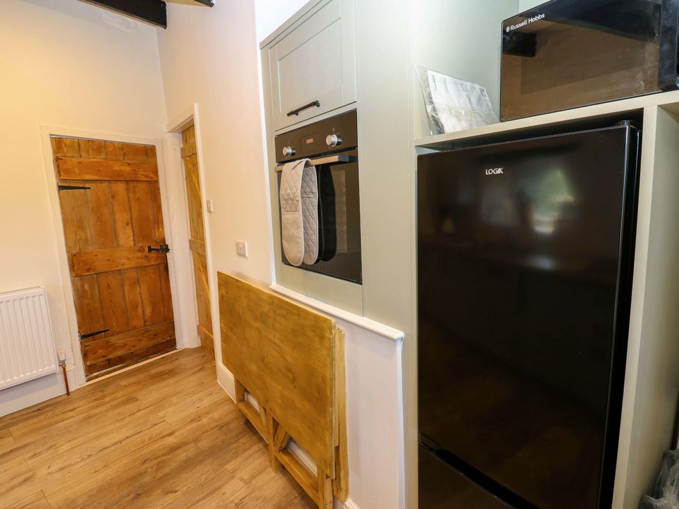A kitchen with an oven, microwave, and refrigerator at Eastend Cottage