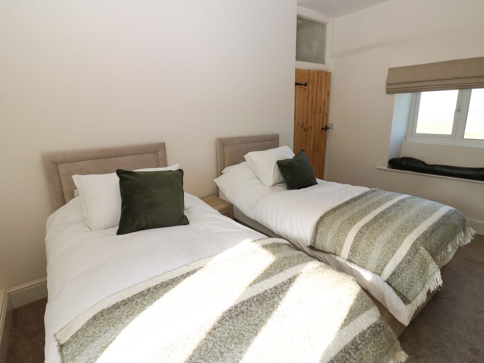 A bedroom with two single beds at Eastend Cottage
