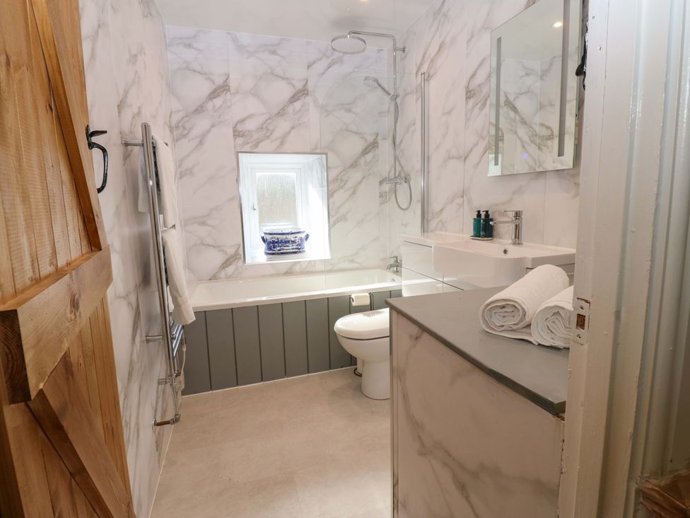A bathroom with a bathtub and shower at Eastend Cottage