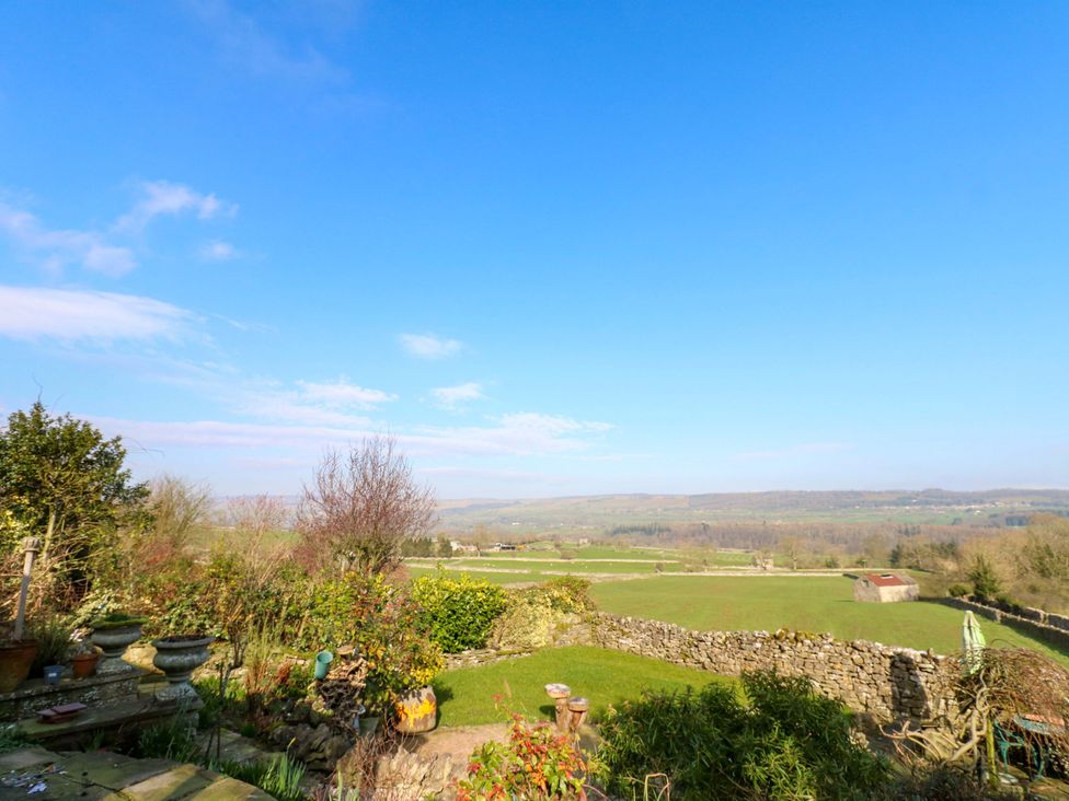 A view of a field and stone wall with trees at Eastend Cottage in 