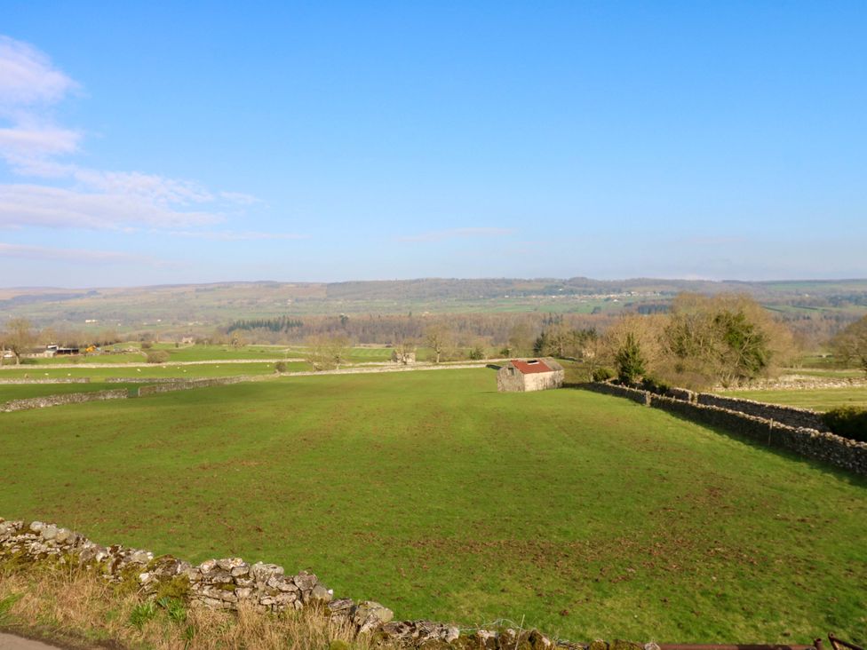 A field with a shed and stone wall at Eastend Cottage in 