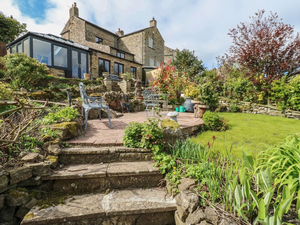 A garden with steps and seating area at Eastend Cottage in West Witton