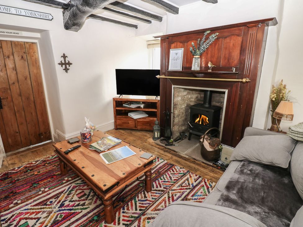 A living room with a television and a fireplace at Eastend Cottage in West Witton