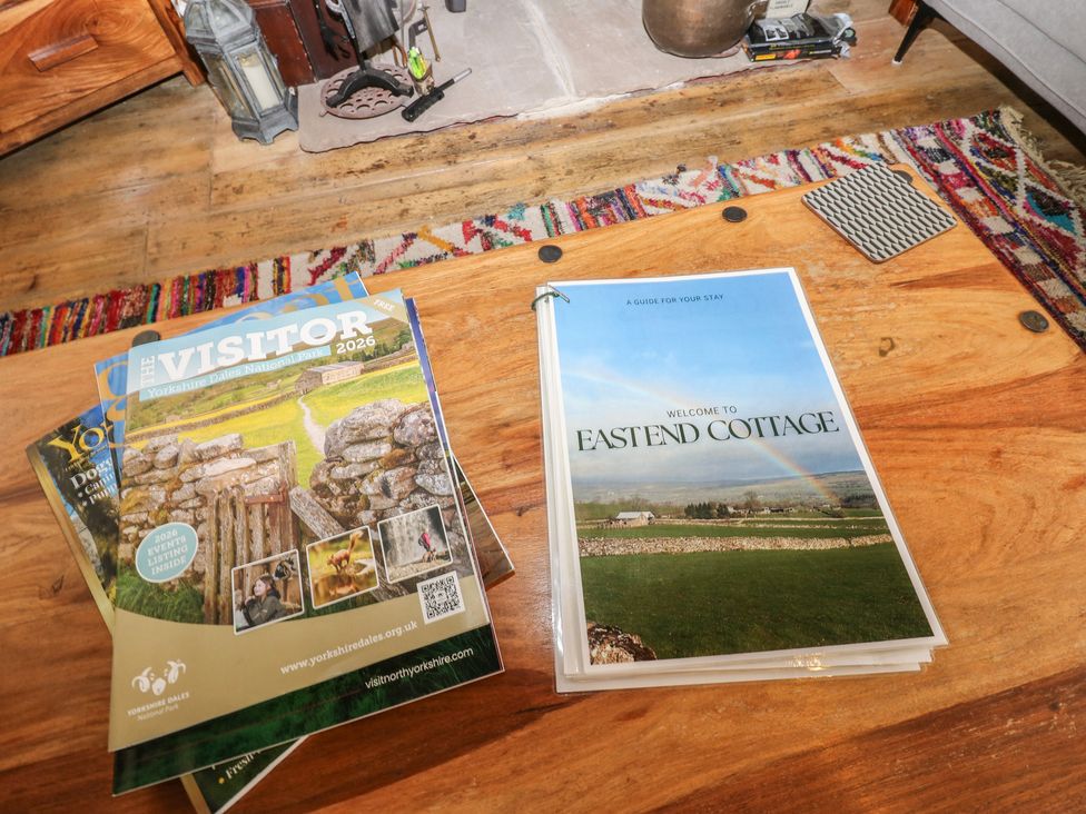 A living room with magazines and a guidebook at Eastend Cottage in West Witton