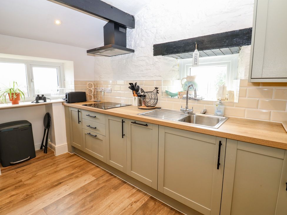 A kitchen with cabinets and a sink at Eastend Cottage in West Witton