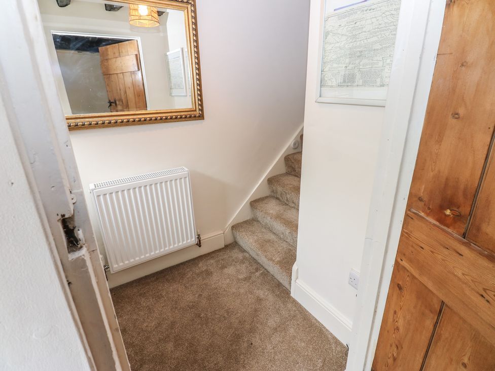 A hallway with a staircase and a radiator at Eastend Cottage, West Witton