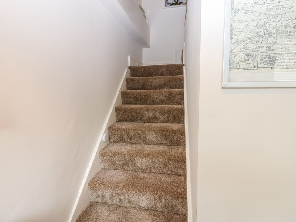 A staircase with carpet leading to upper level at Eastend Cottage in West Witton
