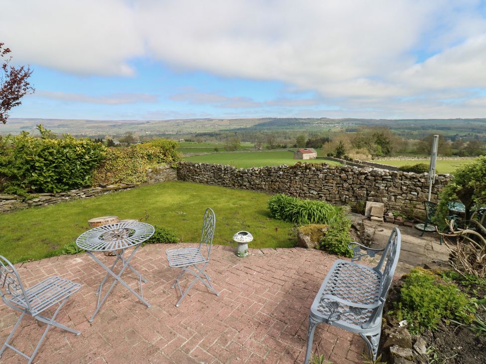 A garden with a table and chairs at Eastend Cottage in West Witton