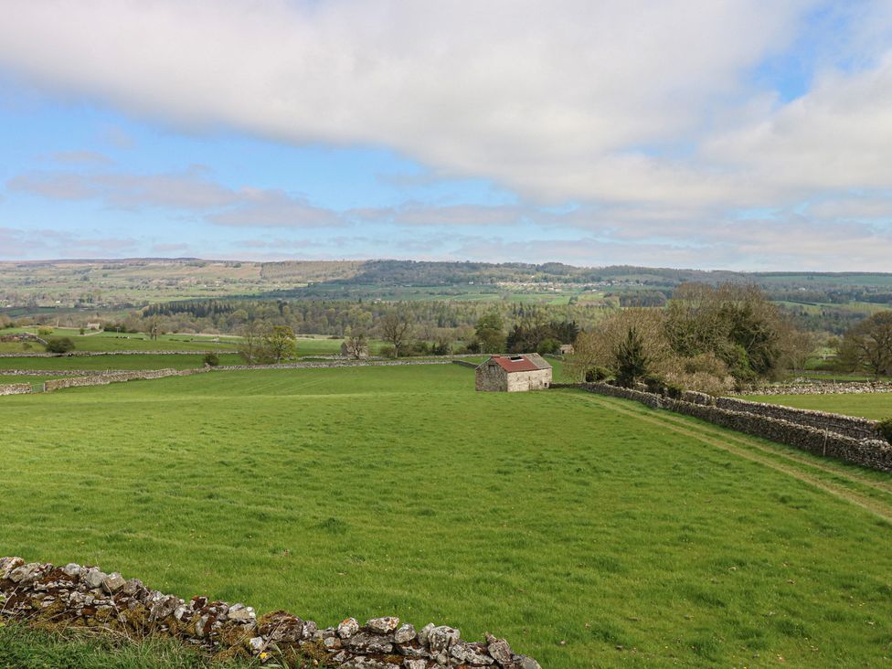 A field with a shed and trees at Eastend Cottage in West Witton