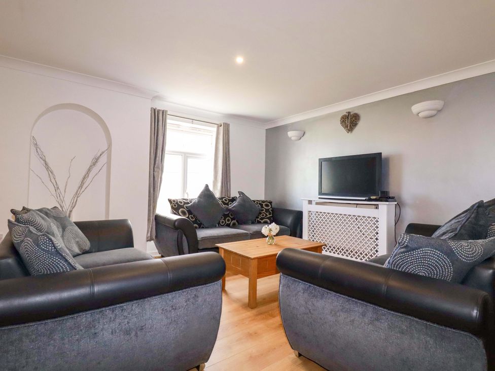 A living room with sofas and a TV at Sea Thrift in White Cross near Indian Queens