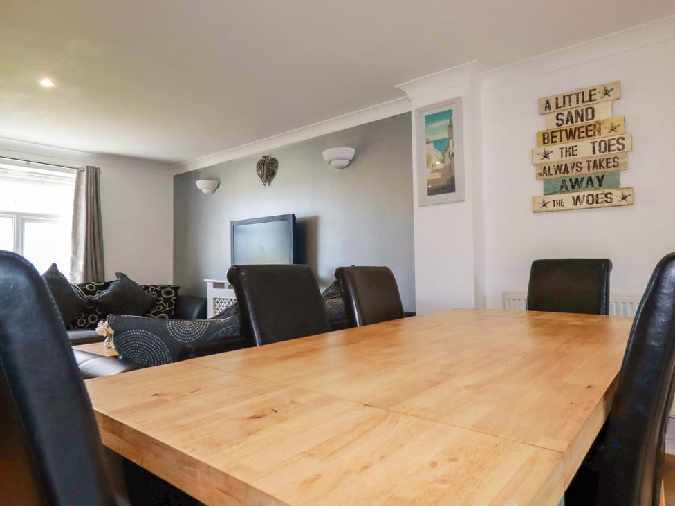 A dining room with a table and chairs at Sea Thrift near White Cross