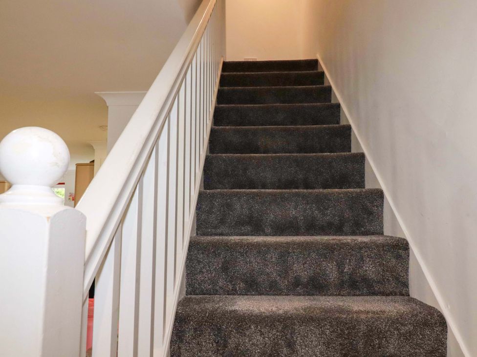 A staircase with carpet steps and a handrail at Sea Thrift near Indian Queens