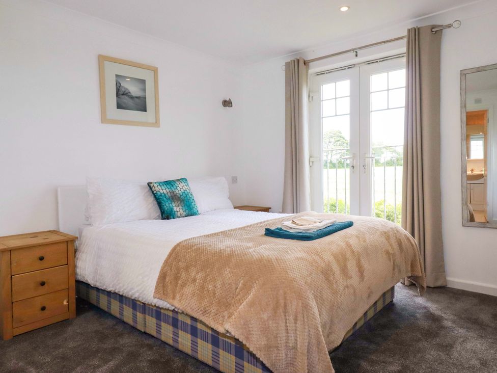 A bedroom with a bed and a nightstand at Sea Thrift in White Cross near Indian Queens