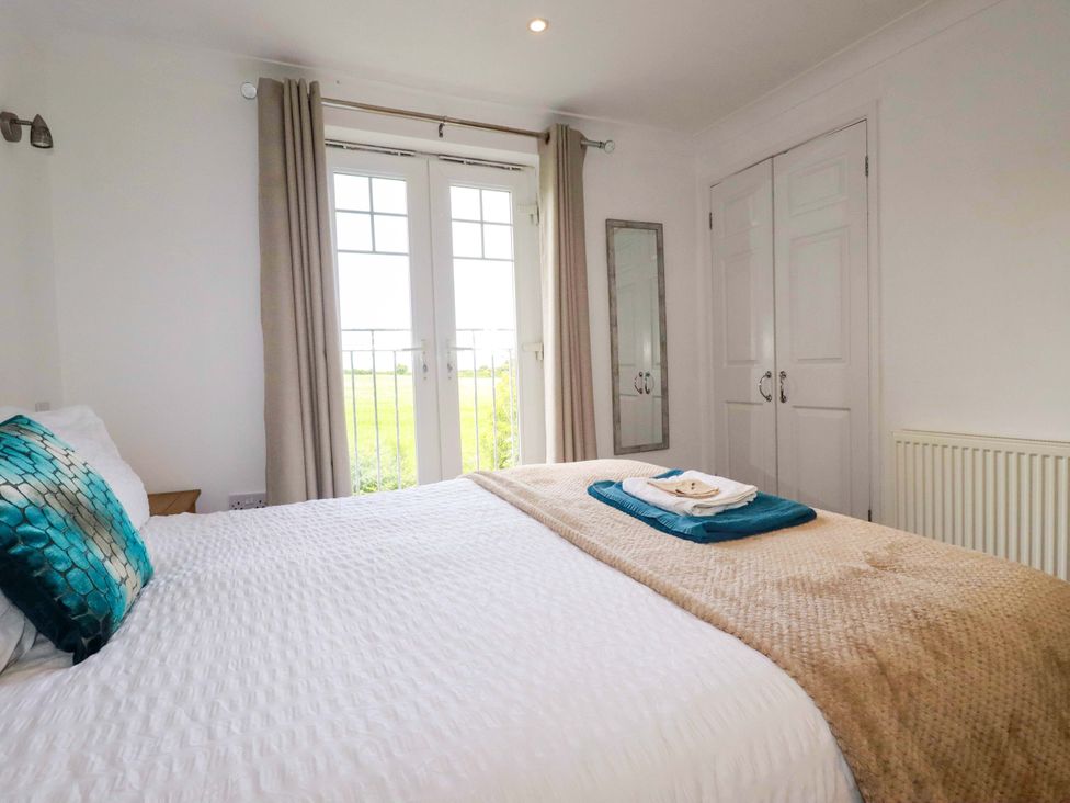 A bedroom with a bed and wardrobe at Sea Thrift in White Cross near Indian Queens