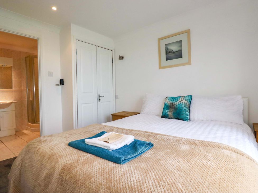 A bedroom with a bed and towels on it at Sea Thrift in White Cross near Indian Queens