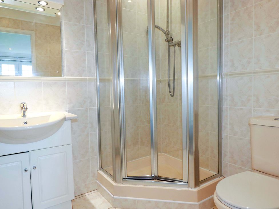 A bathroom with a shower, sink, and toilet at Sea Thrift in White Cross near Indian Queens