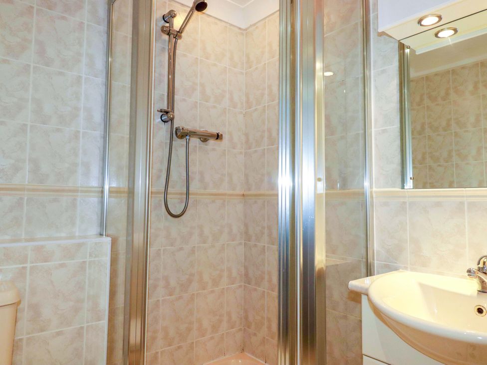 A bathroom with a shower and sink at Sea Thrift in White Cross near Indian Queens