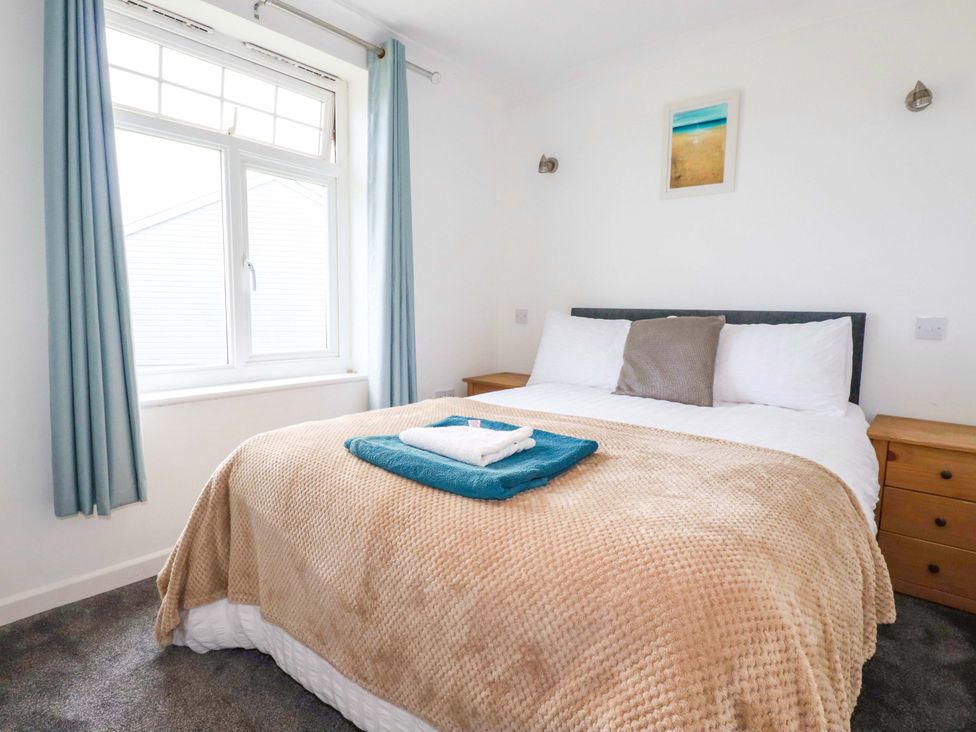 A bedroom with a bed and bedside tables at Sea Thrift in White Cross near Indian Queens