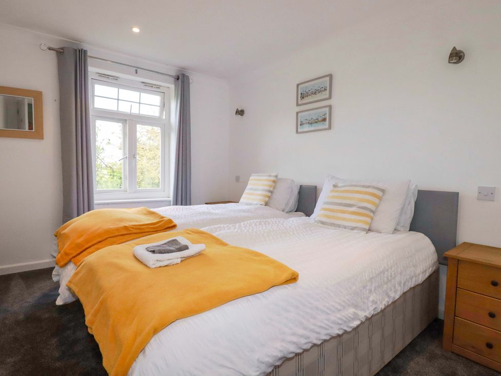 A bedroom with twin beds and a window at Sea Thrift White Cross near Indian Queens
