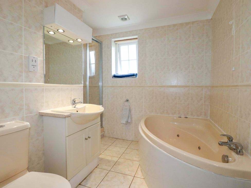 A bathroom with a sink, toilet, shower, and bathtub at Sea Thrift in White Cross near Indian Queens