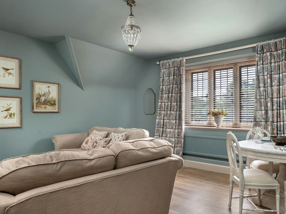 A living room with a sofa and dining table at Whistler Rooms