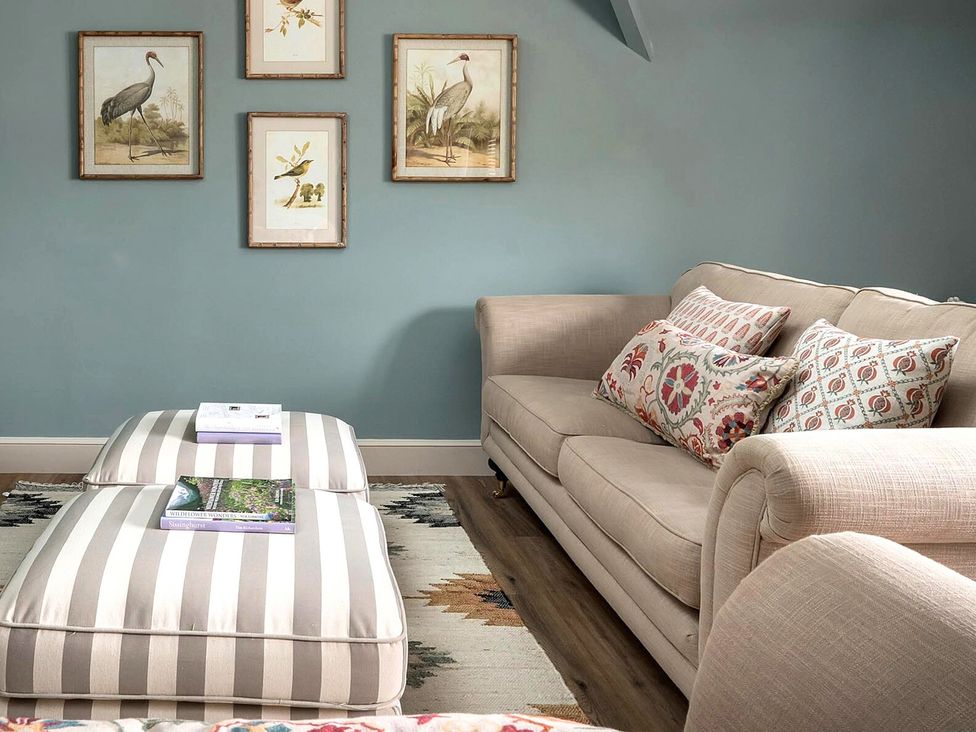 A living room with a sofa and wall art at Whistler Rooms 