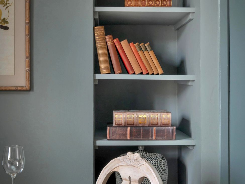 A bookshelf with various books and a decorative object at Whistler Rooms