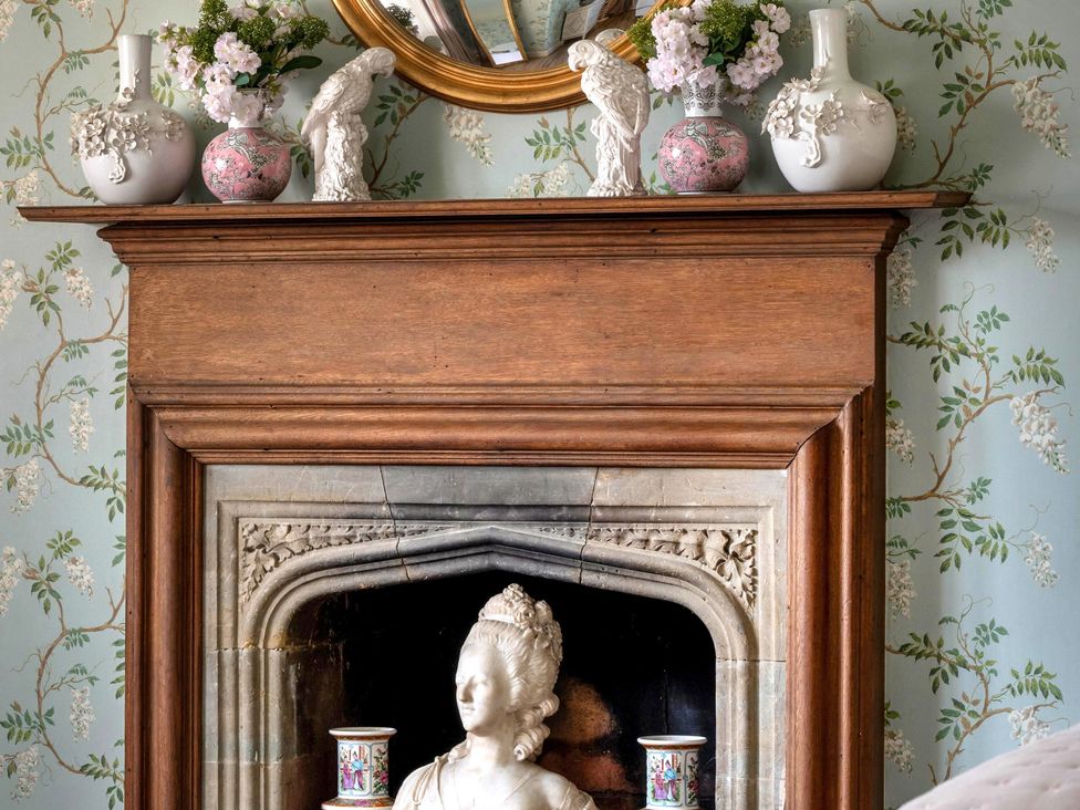 A fireplace with decorative items and a mirror at Whistler Rooms