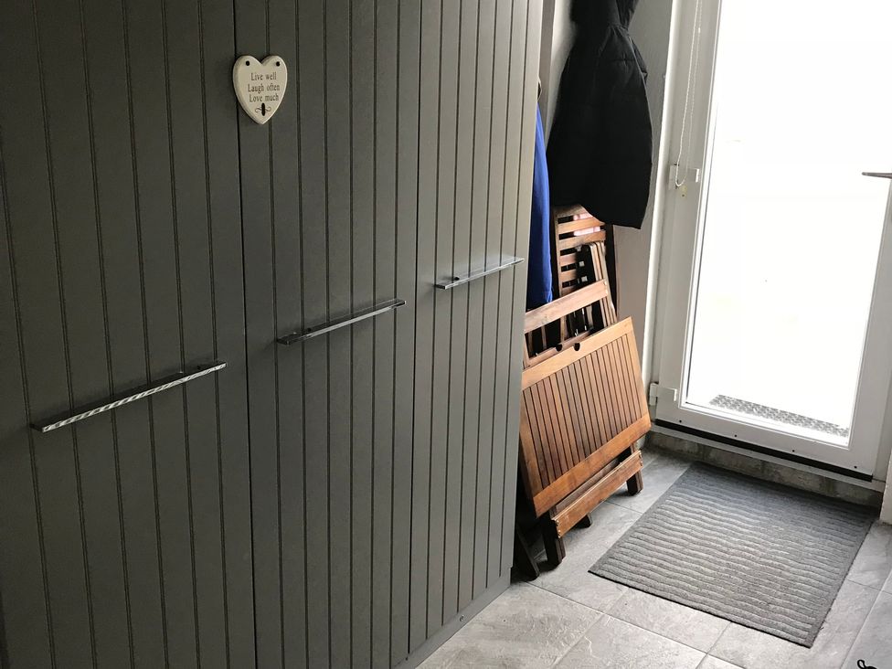 A hallway with a wardrobe and door at Sea Views No 8 Plas Darien in Trearddur Bay