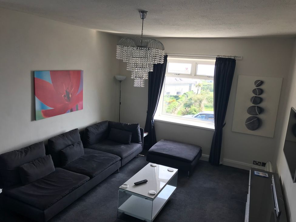 A living room with a sofa and coffee table at Sea Views No 8 Plas Darien in Trearddur Bay