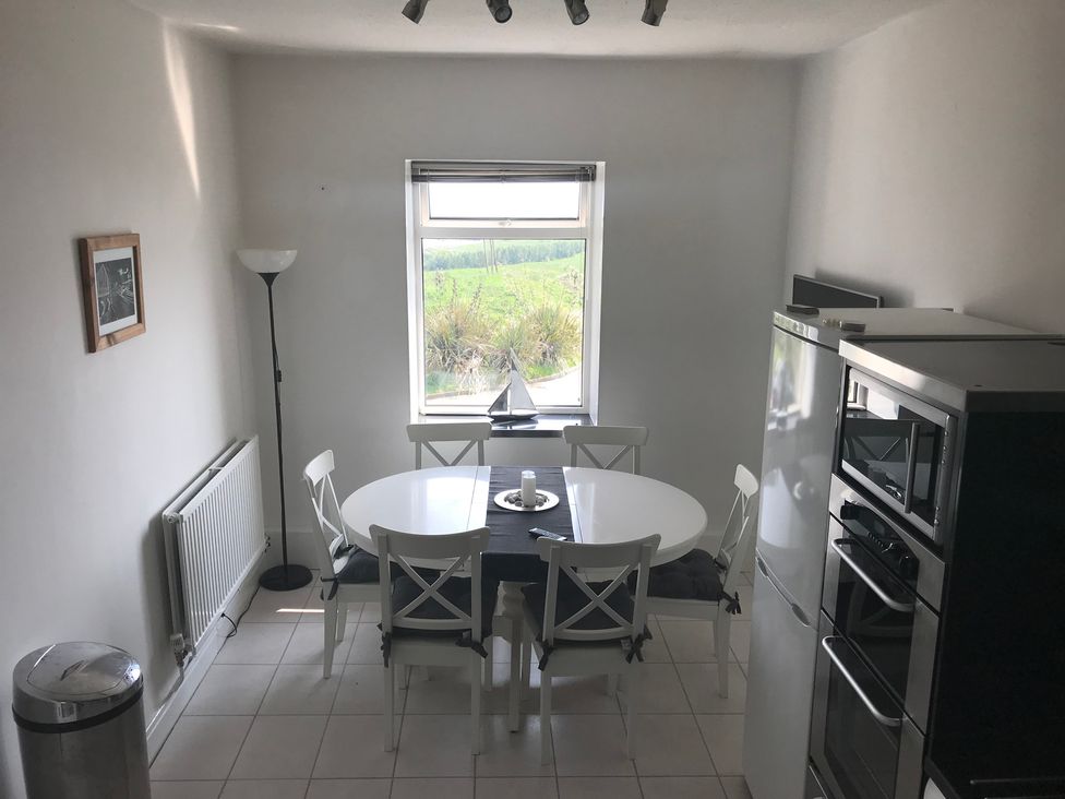A dining room with a table and chairs at Sea Views No 8 Plas Darien Trearddur Bay