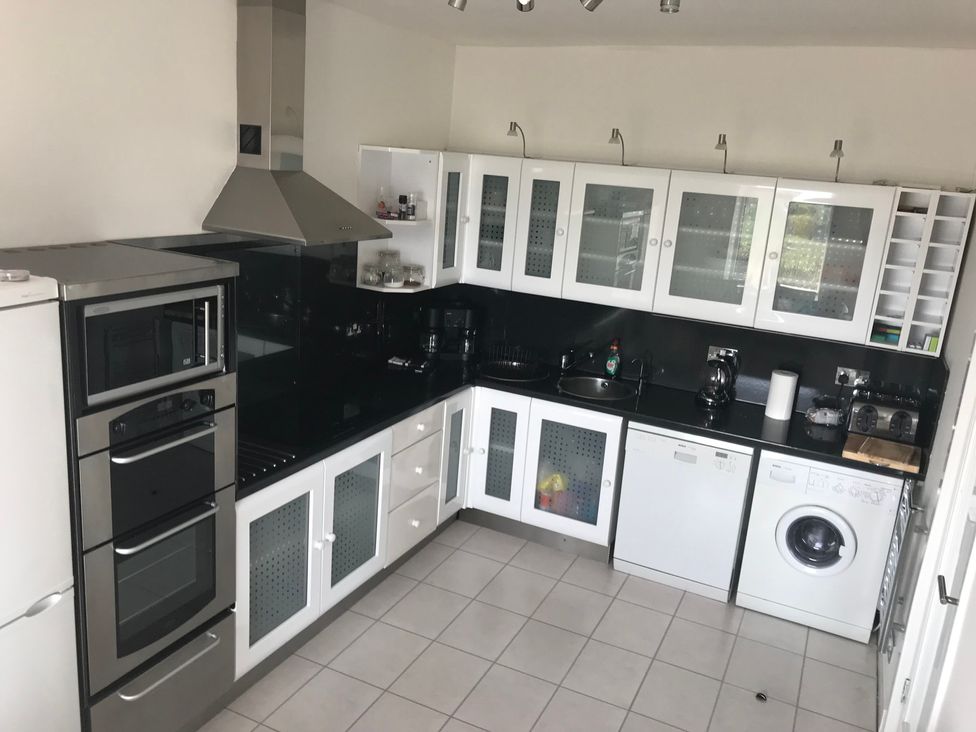 A kitchen with appliances and cabinets at Sea Views No 8 Plas Darien Trearddur Bay