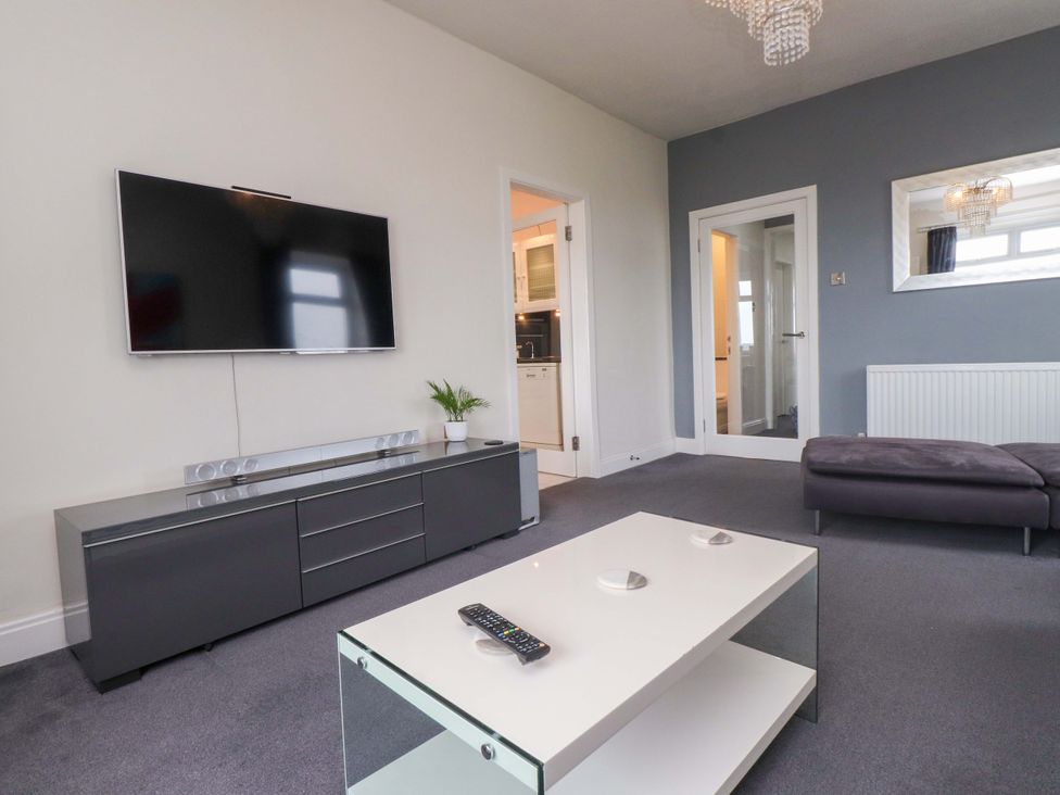 A living room with a TV stand and a coffee table at Sea Views No 8 Plas Darien Trearddur Bay