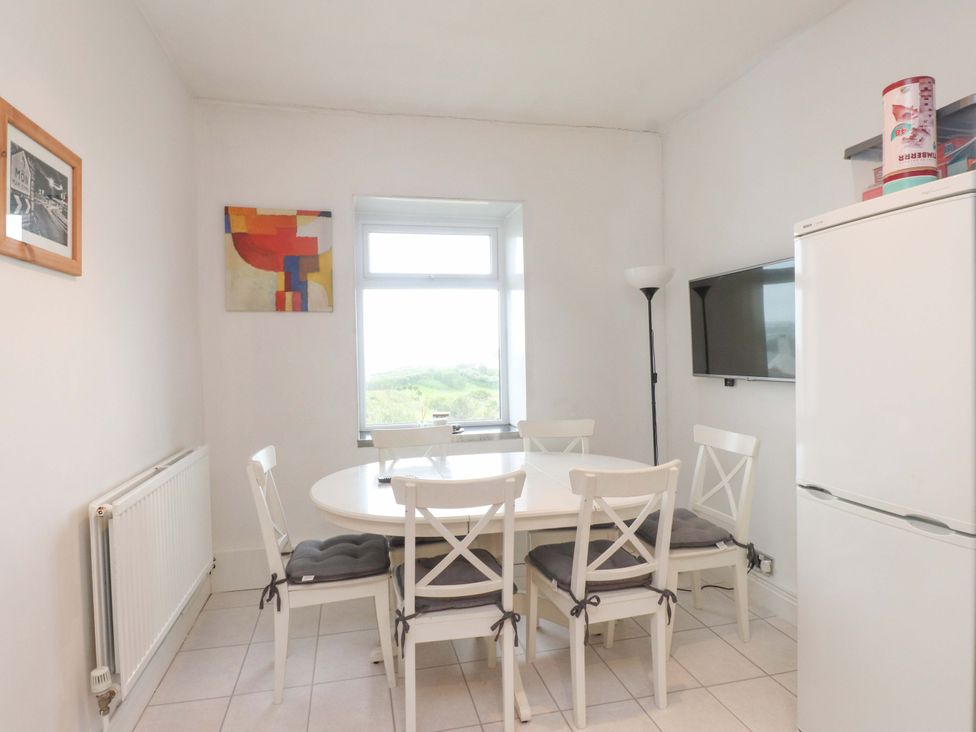 A dining room with a table and chairs at Sea Views No 8 Plas Darien Trearddur Bay