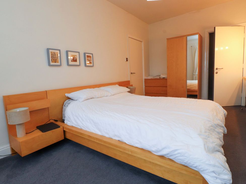 A bedroom with a bed and bedside table at Sea Views No 8 Plas Darien Trearddur Bay