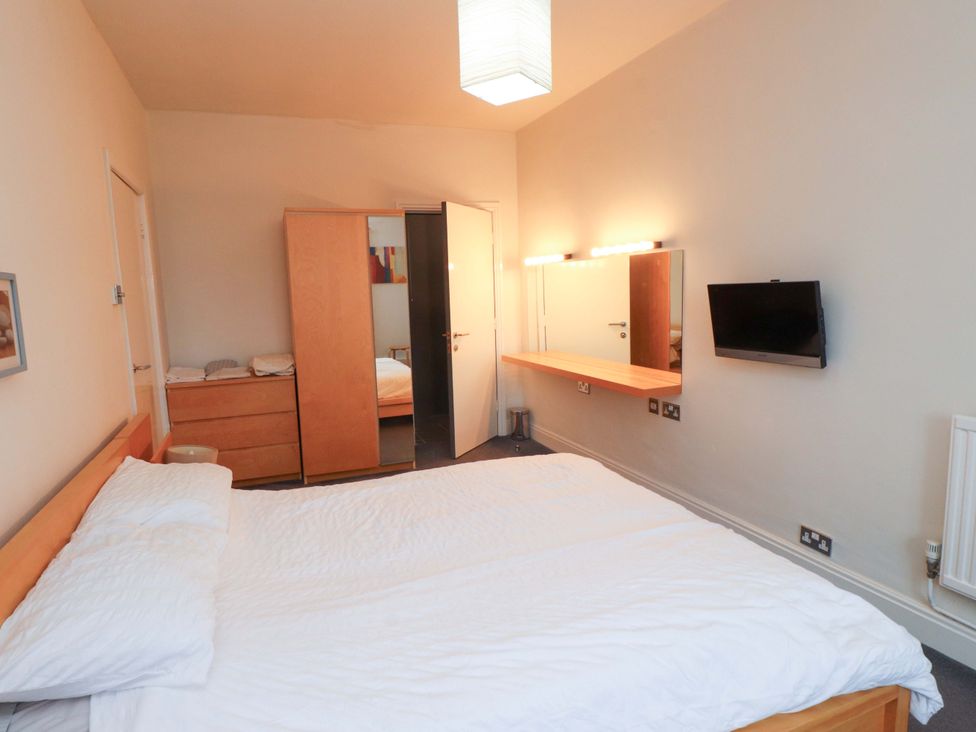 A bedroom with a bed and a television at Sea Views No 8 Plas Darien Trearddur Bay