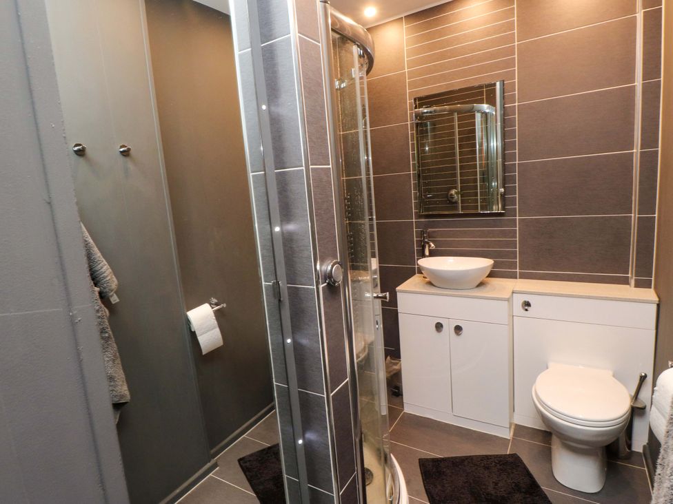 A bathroom with a shower, sink, and toilet at Sea Views No 8 Plas Darien Trearddur Bay