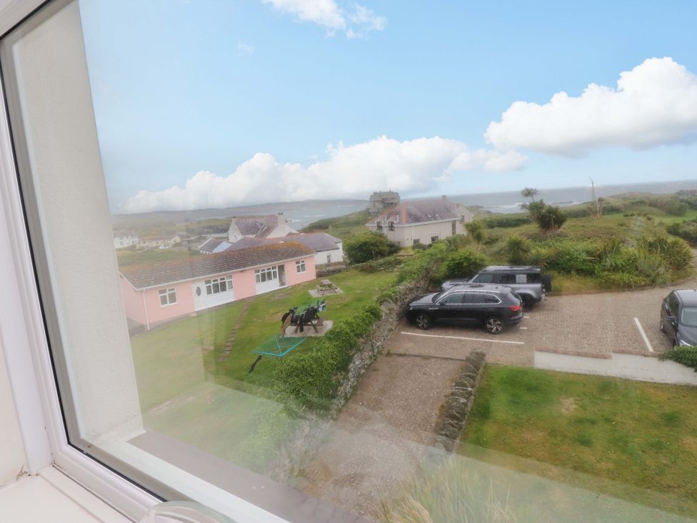 A view from a window showing cars and houses at Sea Views No 8 Plas Darien Trearddur Bay
