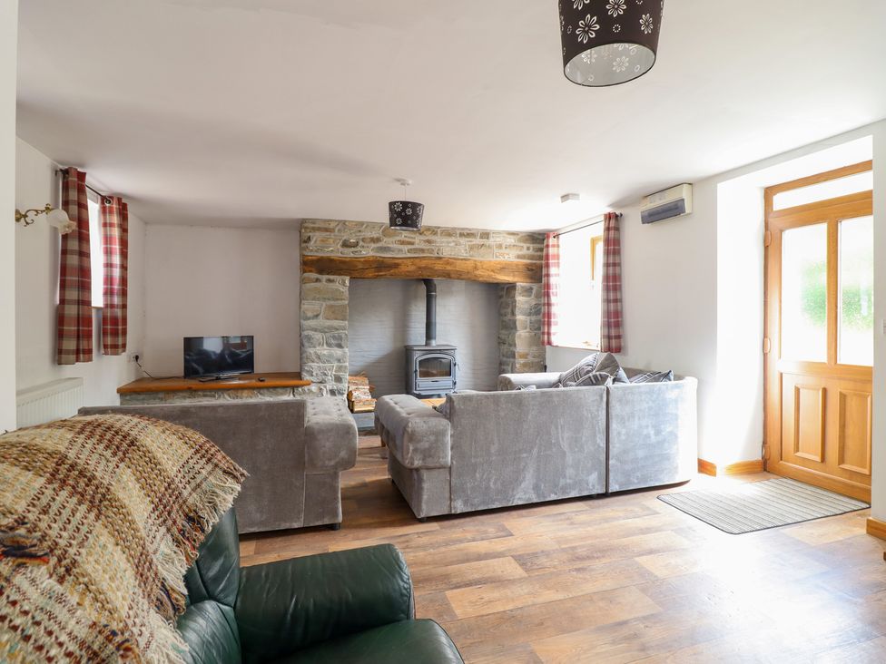 A living room with a sofa and television at Gwernffridd