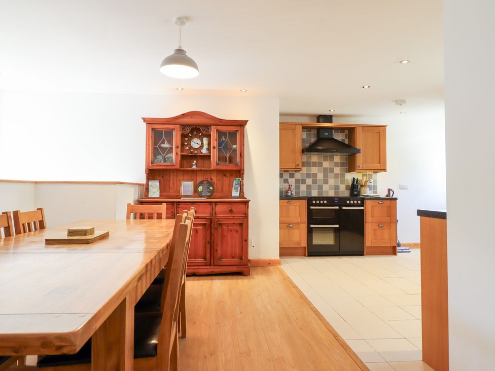 A kitchen with dining table and sideboard at Gwernffridd