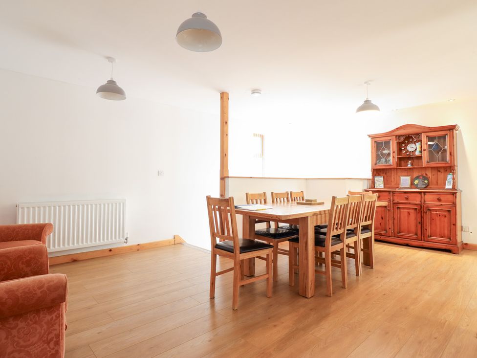 A dining room with a table and chairs at Gwernffridd