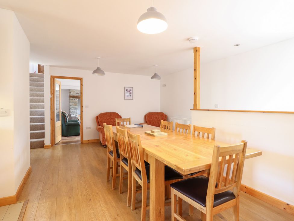 A dining room with a table and chairs at Gwernffridd